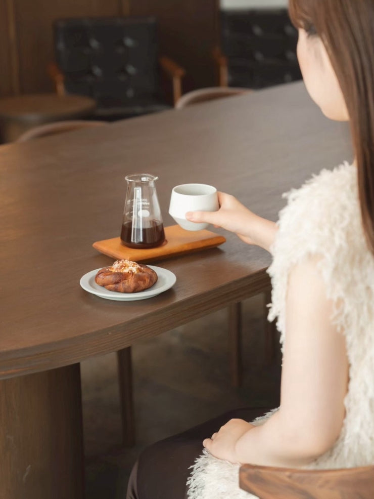 窓辺のテーブルでコーヒーを楽しむ様子