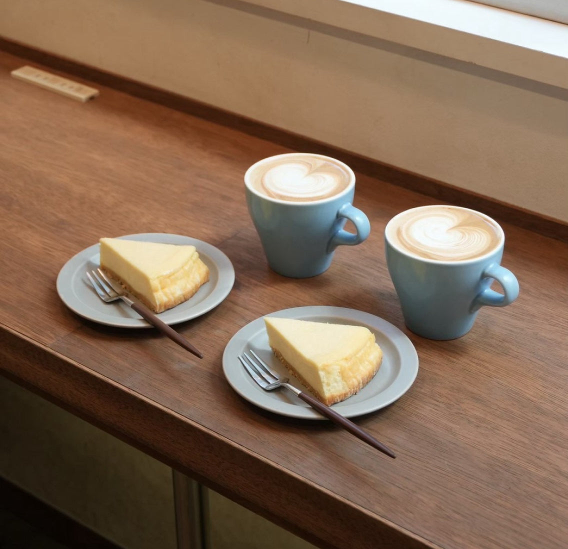 木のテーブルに並ぶコーヒーと焼き菓子
