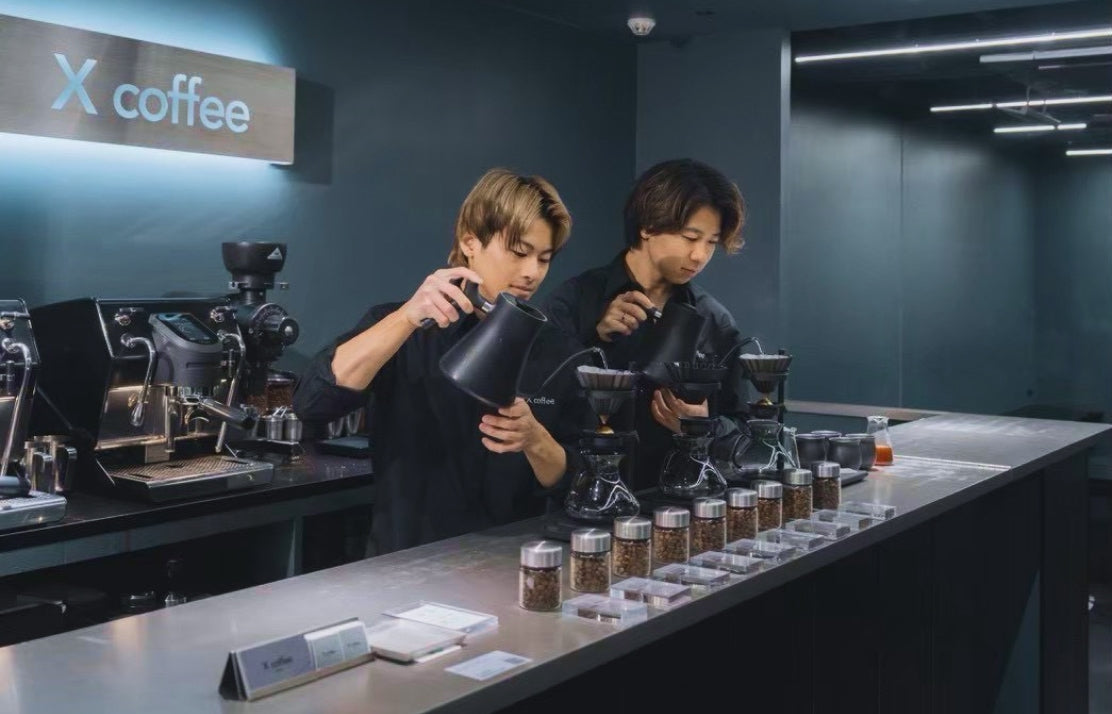 X coffee GINZAのカウンターでコーヒーを抽出する2人