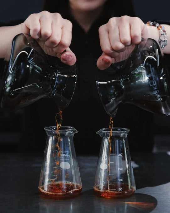 2つの容器にコーヒーを注ぐ手元