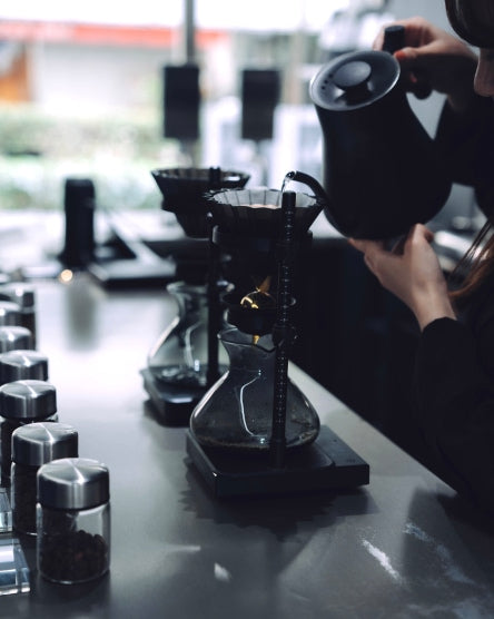 店内のカウンターでコーヒーを抽出するスタッフ